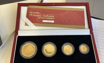 Four encapsulated coins and their paperwork in a presentation box