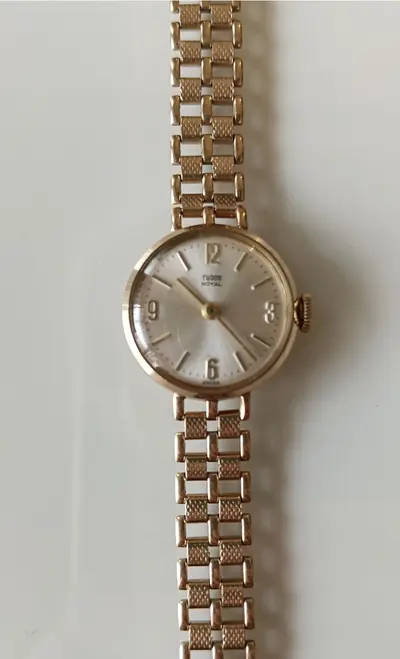 A wristwatch with a linked bracelet on a light surface